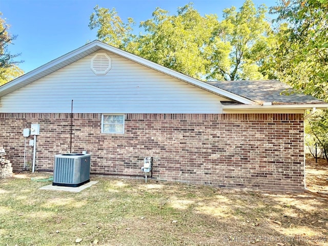 view of home's exterior with cooling unit and a yard