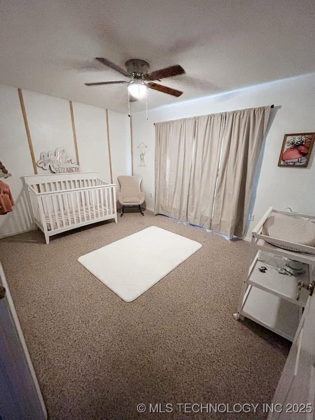 unfurnished bedroom with a crib, carpet flooring, a textured ceiling, and ceiling fan