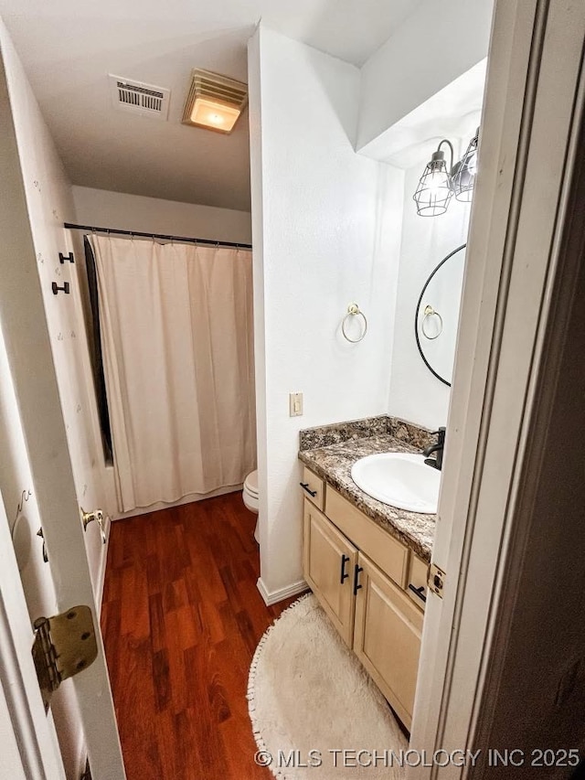 bathroom featuring vanity, hardwood / wood-style flooring, and toilet