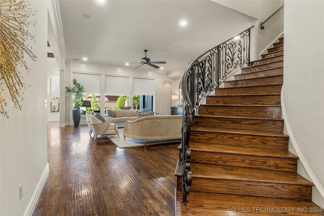 stairway with ceiling fan, hardwood / wood-style flooring, and ornamental molding