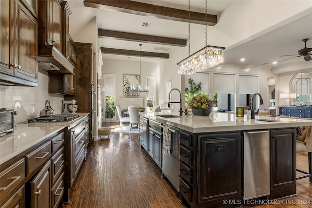 kitchen featuring sink, an island with sink, decorative light fixtures, a breakfast bar area, and dark hardwood / wood-style floors