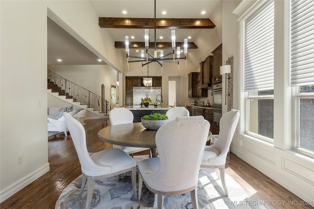 dining room featuring beam ceiling, an inviting chandelier, dark hardwood / wood-style floors, a high ceiling, and sink