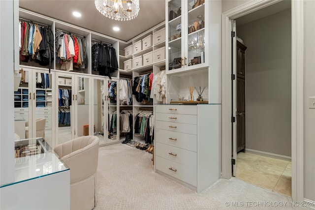 walk in closet with light carpet and a chandelier