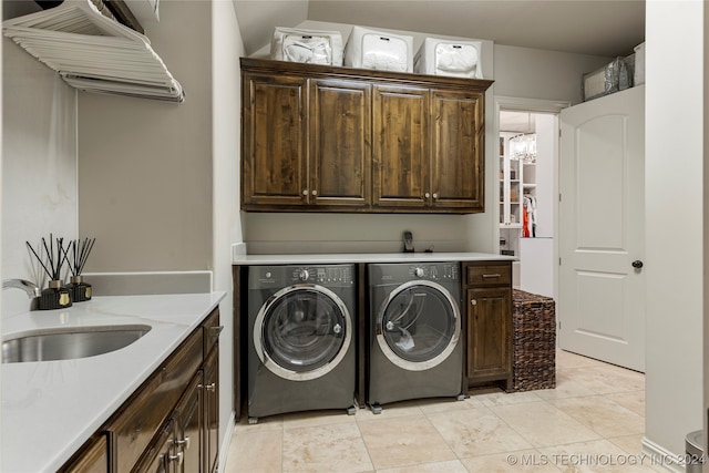 laundry area with sink, washer and clothes dryer, light tile patterned floors, and cabinets