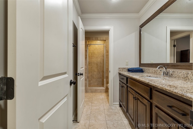 bathroom featuring vanity, crown molding, tile patterned floors, and a shower with shower door