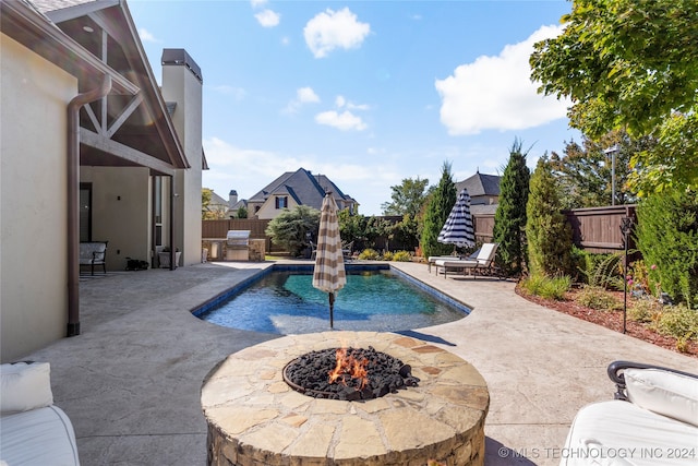 view of swimming pool featuring a patio, a fire pit, and pool water feature