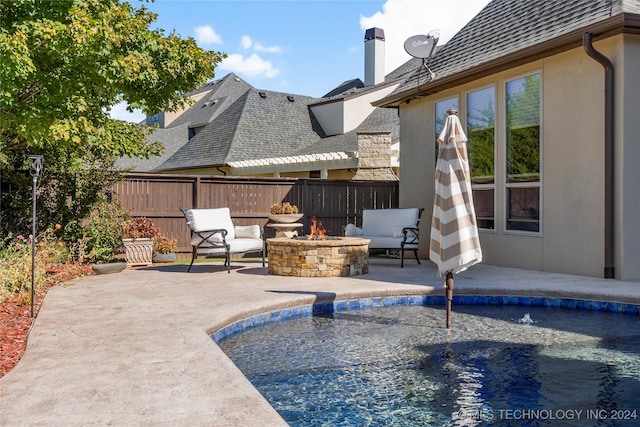 view of pool featuring a patio and an outdoor living space with a fire pit