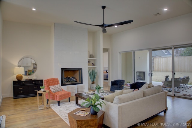 living room featuring ceiling fan and light hardwood / wood-style flooring