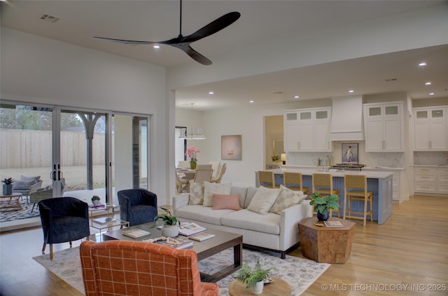 living room with ceiling fan and light hardwood / wood-style flooring