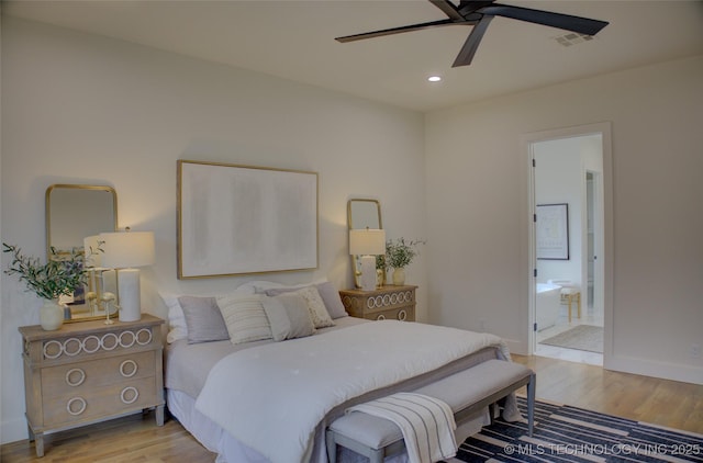 bedroom with ensuite bath, ceiling fan, and light hardwood / wood-style flooring