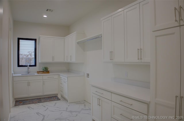 kitchen featuring white cabinetry and sink