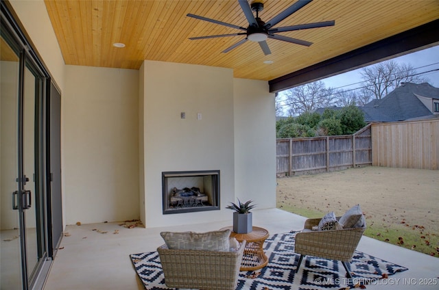 view of patio / terrace with ceiling fan and an outdoor fireplace