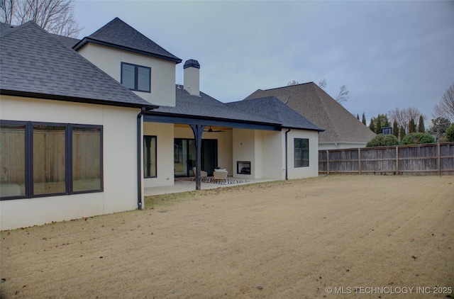 rear view of house with ceiling fan and a patio