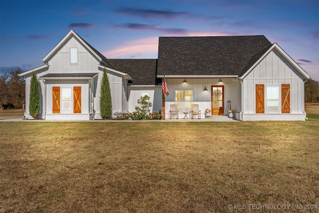 back house at dusk with a lawn