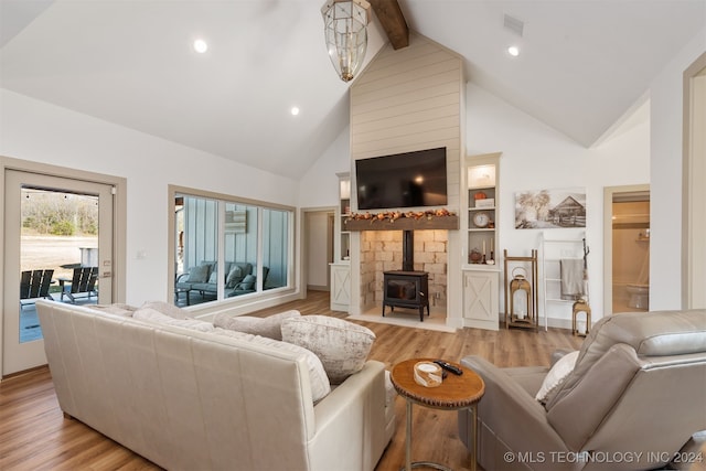 living room featuring high vaulted ceiling, light wood-type flooring, a wood stove, and beamed ceiling