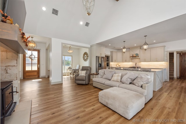 living room with high vaulted ceiling and light hardwood / wood-style floors