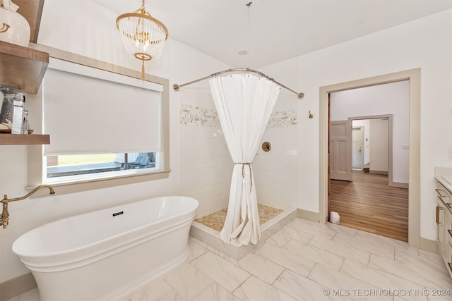 bathroom with vanity, hardwood / wood-style flooring, plus walk in shower, and an inviting chandelier