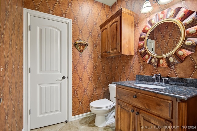 bathroom with toilet, vanity, and tile patterned floors