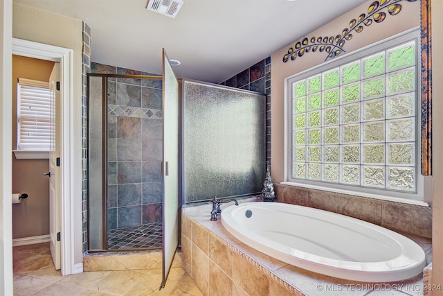 bathroom featuring a healthy amount of sunlight and separate shower and tub