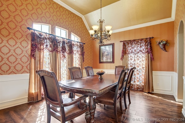 dining area with lofted ceiling, ornamental molding, an inviting chandelier, and dark hardwood / wood-style flooring