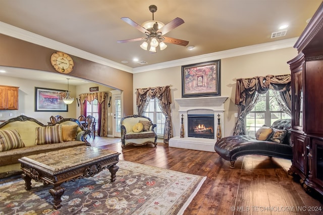 living room with dark wood-type flooring, ceiling fan, and ornamental molding