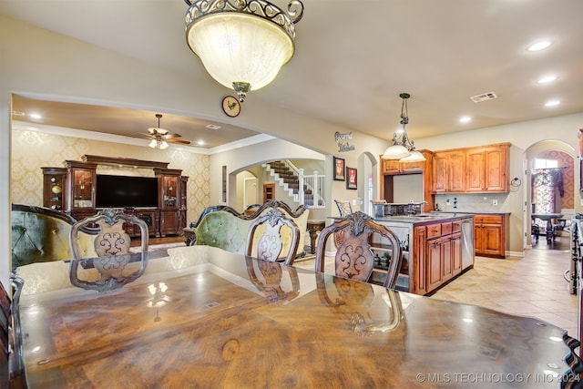 dining area featuring ornamental molding, light tile patterned flooring, sink, and ceiling fan