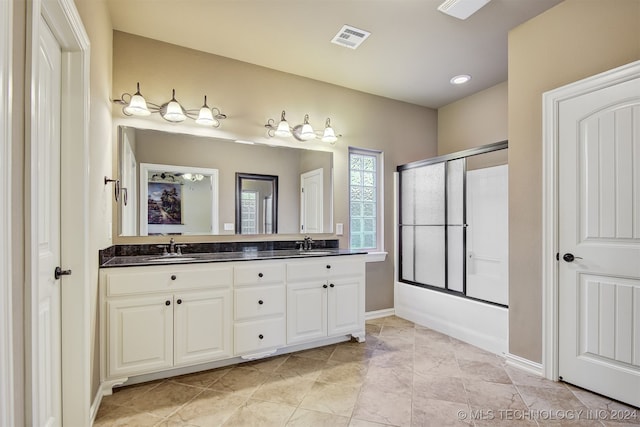 bathroom with vanity and bath / shower combo with glass door