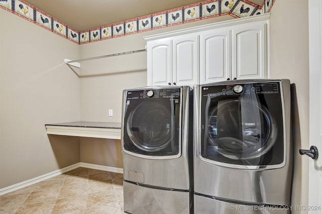 clothes washing area featuring washer and dryer and cabinets