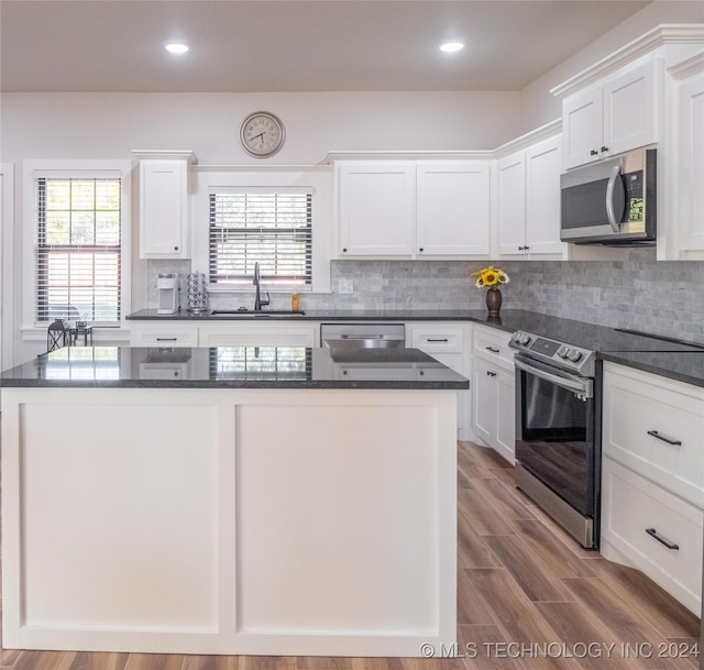 kitchen with stainless steel appliances, sink, light wood-type flooring, and white cabinets