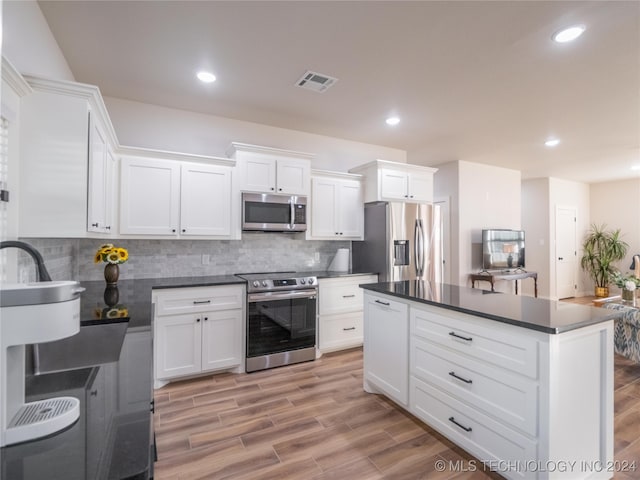 kitchen with backsplash, a center island, light wood-type flooring, white cabinetry, and appliances with stainless steel finishes