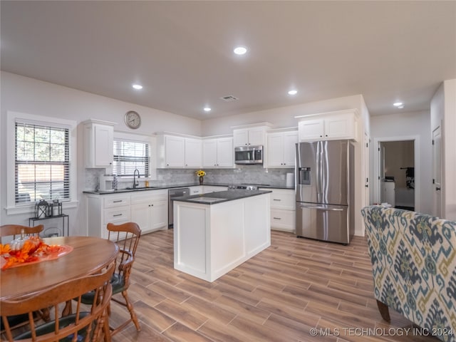 kitchen featuring light hardwood / wood-style floors, appliances with stainless steel finishes, and white cabinets