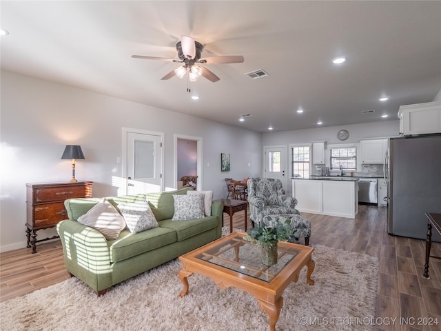 living room featuring dark hardwood / wood-style floors, sink, and ceiling fan