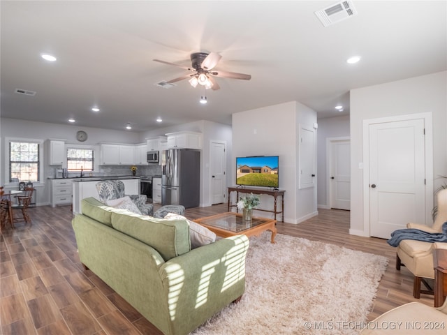 living room featuring sink, hardwood / wood-style floors, and ceiling fan