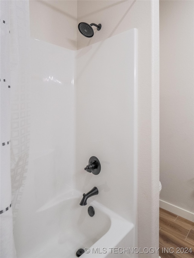 bathroom featuring bathing tub / shower combination and wood-type flooring