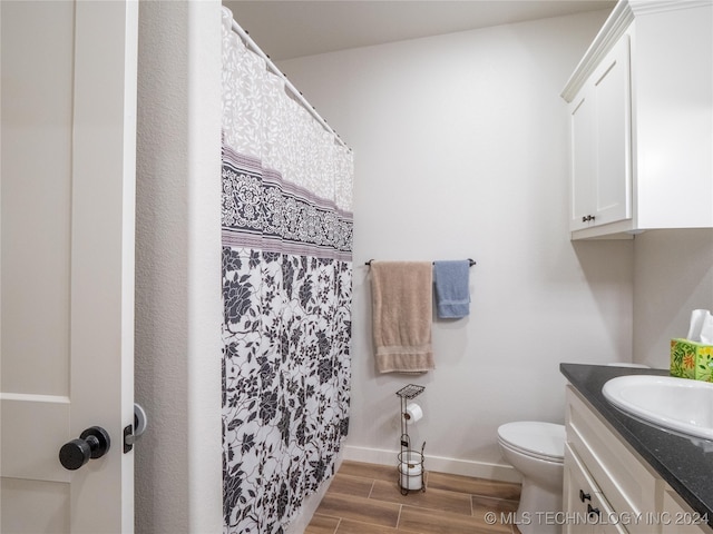 bathroom featuring vanity, wood-type flooring, and toilet