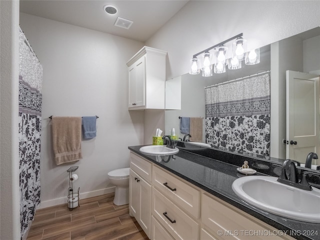 bathroom featuring vanity, hardwood / wood-style floors, and toilet