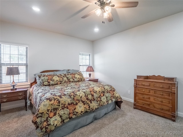 bedroom featuring ceiling fan, carpet flooring, and multiple windows