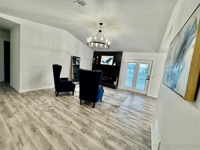 interior space with an inviting chandelier, vaulted ceiling, and light wood-type flooring