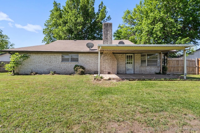 back of property with a yard and a patio area