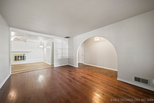 unfurnished living room with ceiling fan and dark hardwood / wood-style flooring