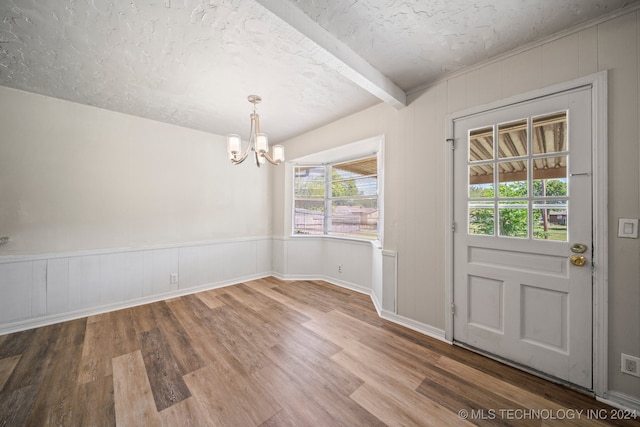 entryway featuring beam ceiling, a textured ceiling, an inviting chandelier, and hardwood / wood-style floors