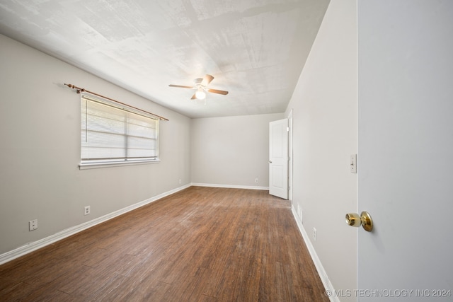 unfurnished room with dark wood-type flooring and ceiling fan