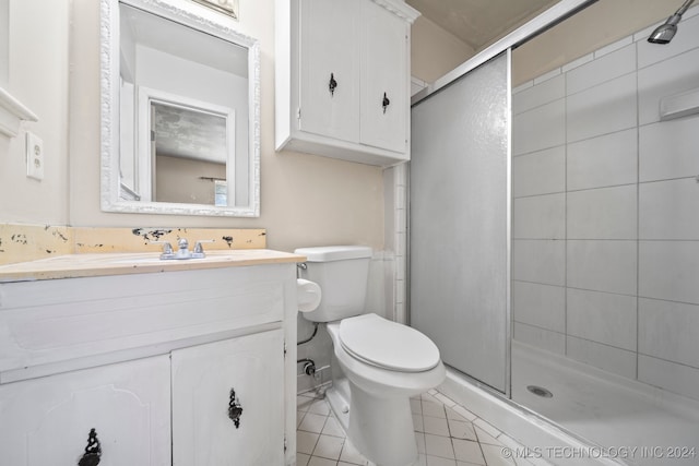 bathroom featuring vanity, tile patterned flooring, toilet, and walk in shower