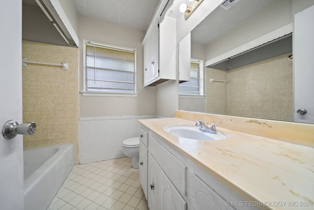 full bathroom featuring vanity, toilet, tiled shower / bath combo, and a wealth of natural light