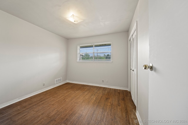 empty room with dark hardwood / wood-style flooring