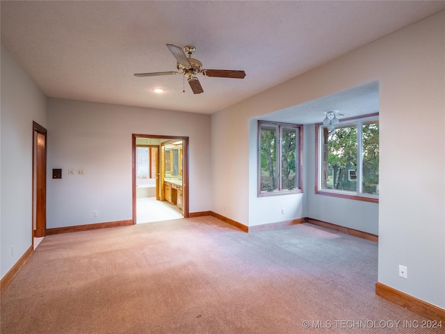 unfurnished room featuring light colored carpet and ceiling fan