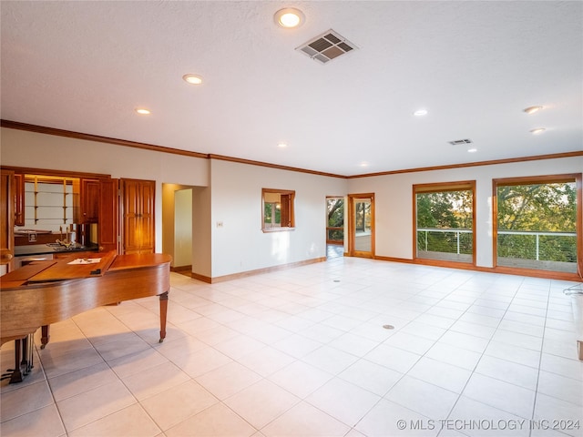 unfurnished living room with crown molding and light tile patterned flooring