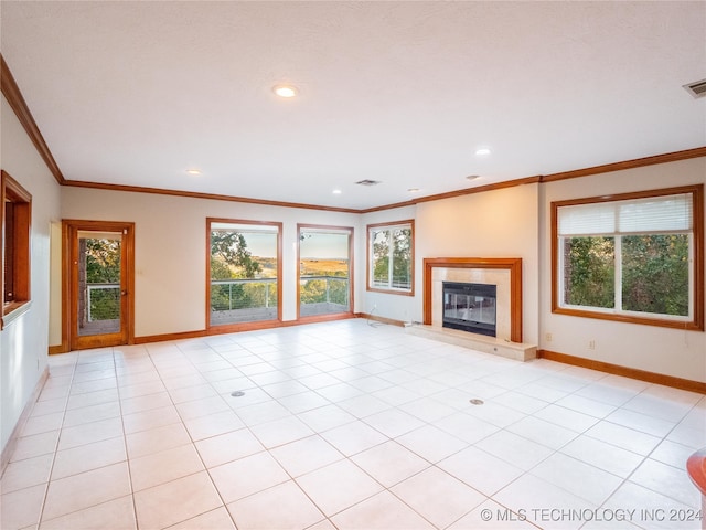 unfurnished living room with crown molding, a tile fireplace, and light tile patterned floors