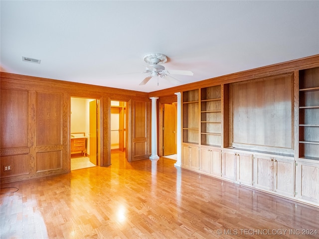 unfurnished living room featuring decorative columns, built in features, light wood-type flooring, and ceiling fan