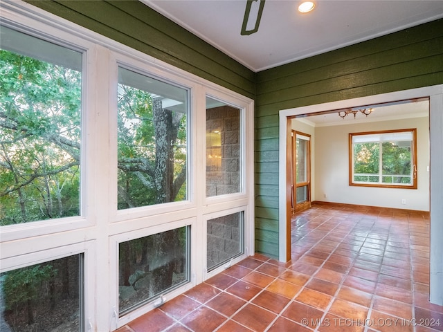 unfurnished sunroom featuring a wealth of natural light and a chandelier